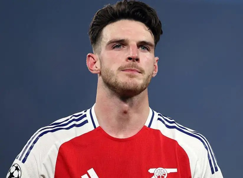 德克蘭·賴斯(Declan Rice)身穿阿森納紅白球衣,在比賽場邊注視前方。
