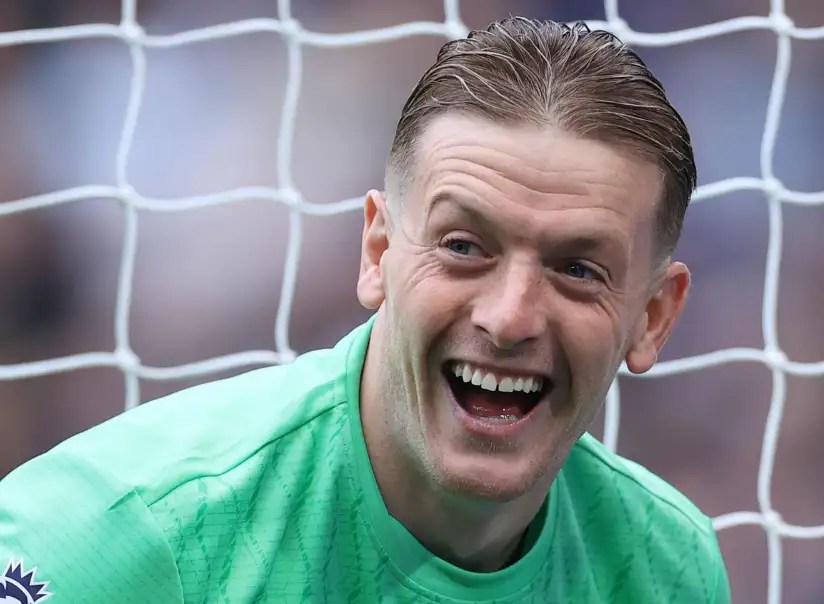 喬丹·皮克福德(Jordan Pickford)身穿綠色守門員球衣,在球門前露出笑容的畫面。