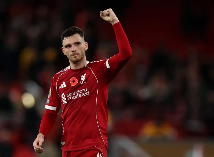 安迪·羅伯森（Andy Robertson）身穿利物浦紅色球衣，在球場上舉起右拳向觀眾致意