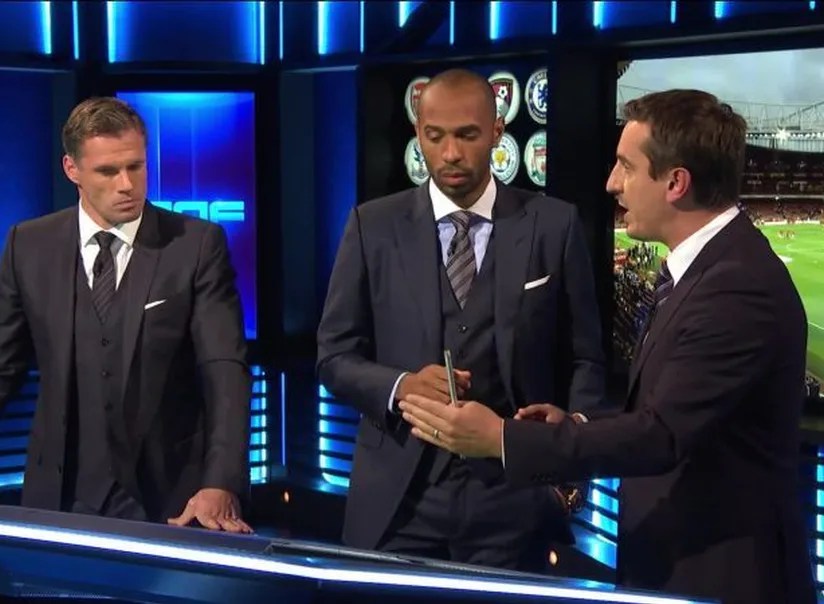 Four football pundits sitting around a plasma screen in a TV studio debating the future of football in 2036