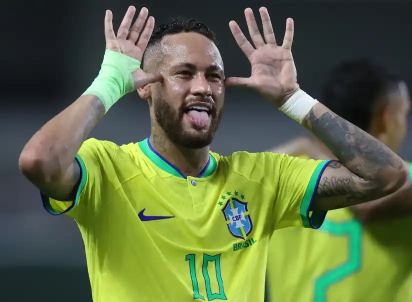 內馬爾（Neymar）身穿巴西黃色球衣，在球場上吐舌並雙手張開放在臉旁慶祝